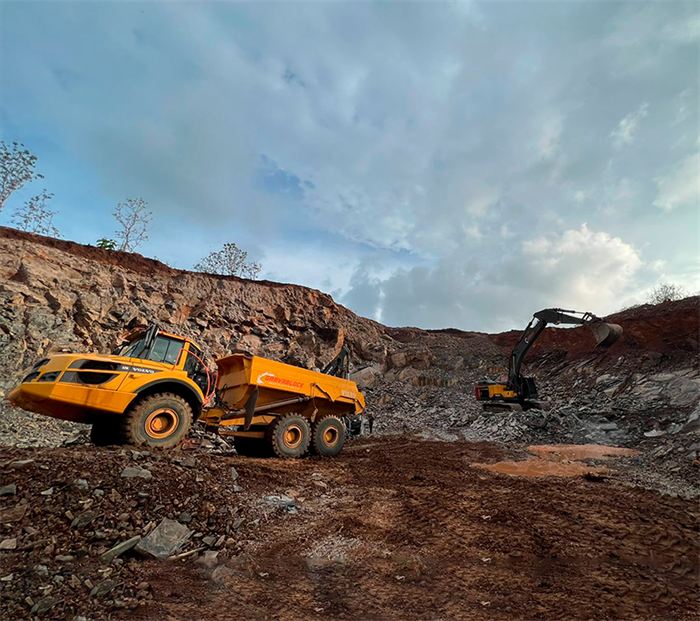 Camión articulado y excavadora en la zona de extracción